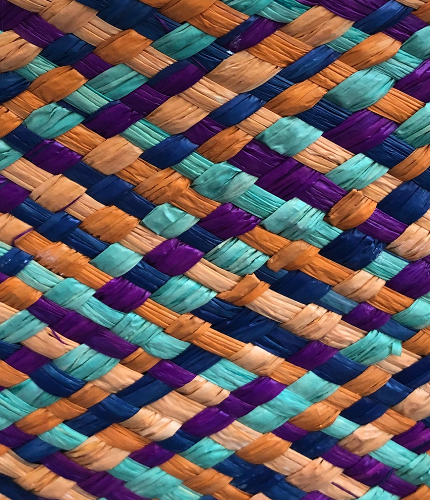 Detail view of Pianina Turquoise Multi Small Straw Basket Bag handmade from woven natural raffia palm fiber in a multicolor cross weave pattern of turquoise blue, melon orange, orchid purple, and navy blue handbag purse with leather handles - Shebobo