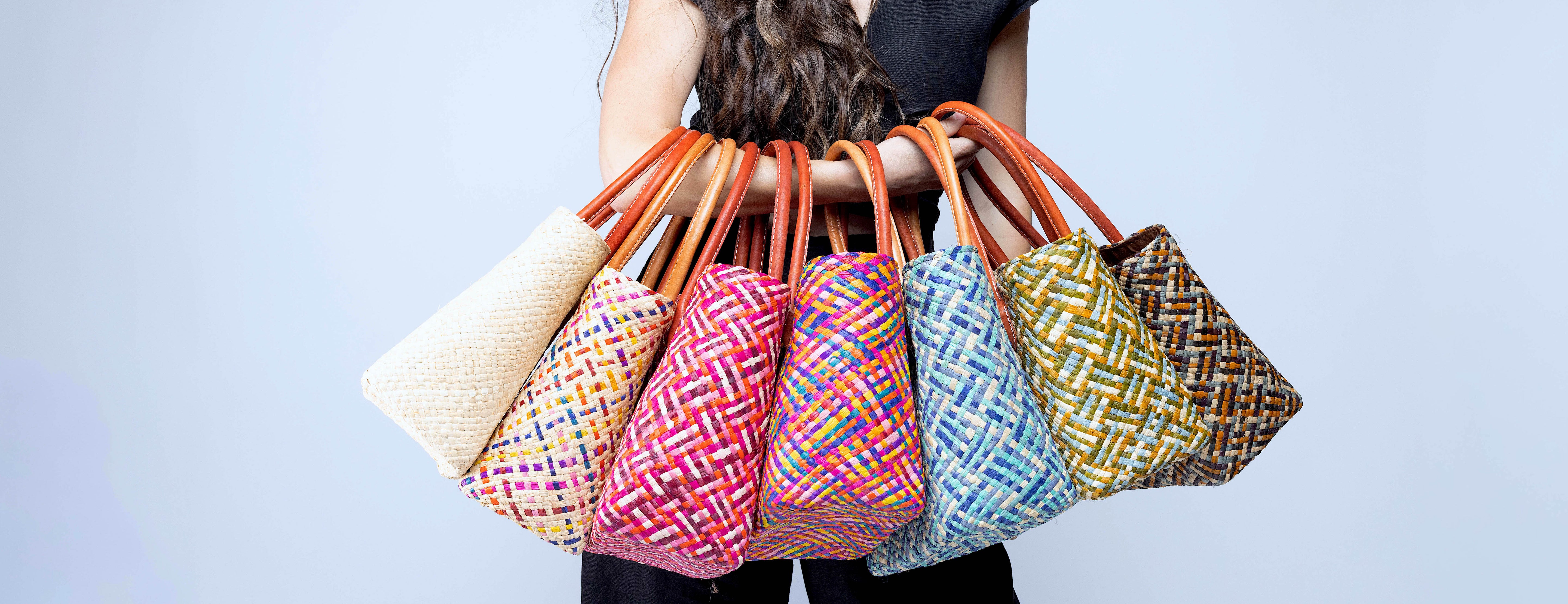 Model wearing multiple color options of Pianina Small Straw Basket Bags handmade from woven natural raffia palm fiber in a multicolor cross weave patterns handbag purse with leather handles - Shebobo