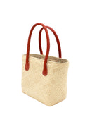 Side view Pianina Natural Small Straw Basket Bag handmade from woven natural raffia palm fiber in a monochromatic cross weave pattern of natural straw color handbag purse with leather handles - Shebobo
