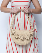 Model wearing Piper Crochet Flower Straw Handbag with Macrame Chain Strap handmade natural raffia palm fiber in a solid hue of natural straw color with delicate 3D floral edge along the front envelope flap style closure of the half moon shaped bag with subtle curved banding and macrame chain shoulder strap purse small bag shoulder bag - Shebobo