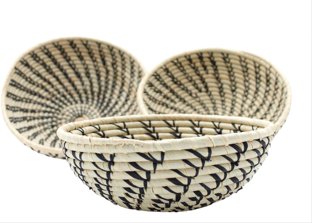 Side view Raffia Straw Decor Display Basket Bowls: Set of 3 handmade woven natural raffia palm fiber in a crochet loop technique concentric coiled circular pattern with natural straw color centered in the bottom and that go up the sides of the bowls with contrasting black swirl stitch pattern and matching natural rim/edge set of small, medium, and large straw display bowls - Shebobo