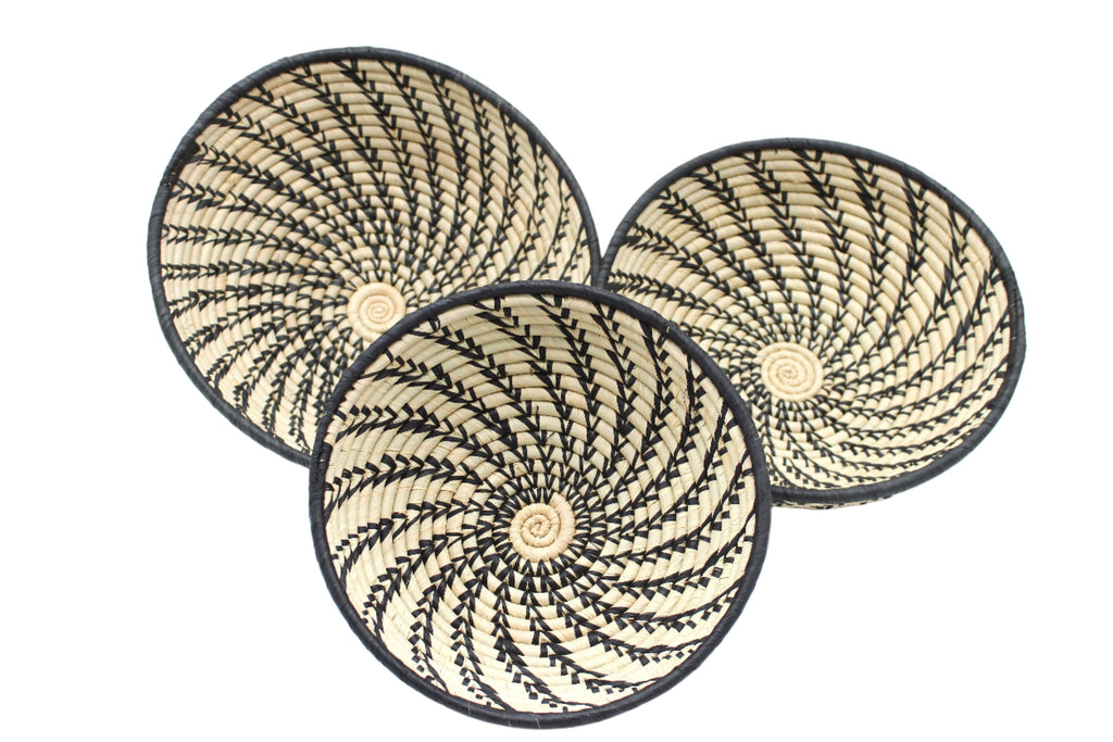 Raffia Straw Decor Display Basket Bowls: Set of 3 handmade woven natural raffia palm fiber in a crochet loop technique concentric coiled circular pattern with natural straw color centered in the bottom and that go up the sides of the bowls with contrasting black swirl stitch pattern and matching black rim/edge set of small, medium, and large straw display bowls - Shebobo