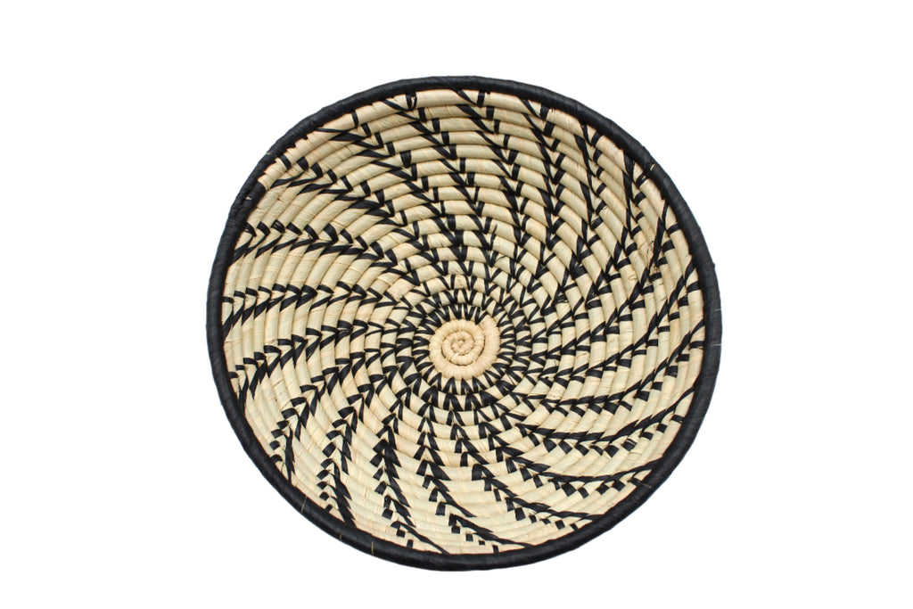 Detail view Raffia Straw Decor Display Basket Bowls: Set of 3 handmade woven natural raffia palm fiber in a crochet loop technique concentric coiled circular pattern with natural straw color centered in the bottom and that go up the sides of the bowls with contrasting black swirl stitch pattern and matching black rim/edge set of small, medium, and large straw display bowls - Shebobo