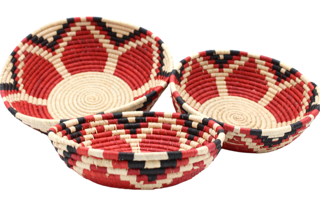 Side view Raffia Straw Decor Display Basket Bowls: Set of 3 handmade woven natural raffia palm fiber in a crochet loop technique concentric coiled circular pattern with natural straw color centered in the bottom with red, natural, and black geometric floral design pattern up the sides of the bowls set of small, medium, and large straw display bowls - Shebobo