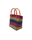 Side view Rayo Stripes Straw Basket Bag Blueberry Swirl handmade loomed natural raffia palm fiber in a multicolor multi width horizontal stripe pattern of fuchsia hot/bright/barbie/pink, dusk navy/dark/blue, midori lime/neon/green with leather handles and accents tote beach bag - Shebobo