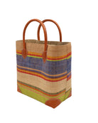 Side view Rayo Stripes Straw Basket Bag Rio Swirl handmade loomed natural raffia palm fiber in a multicolor multi width horizontal stripe pattern of midori lime/green, navy dark/blue, coral orange/red, saffron yellow/orange, red, martini olive/green, purple, red, and natural straw color with leather handles and accents tote beach bag - Shebobo