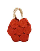 Romy Coral Crochet Disc Straw Handbag with Wooden Bead Handles handmade natural raffia palm fiber in a solid hue of coral orange/red in a crochet coiled circular flat disc attached together with macrame knot technique with a geometric hexagonal overall shape with seven discs per side two above and below a horizontal row of three per side and a single row comprising the side of the bag with beige carved round wooden beaded handles purse - Shebobo