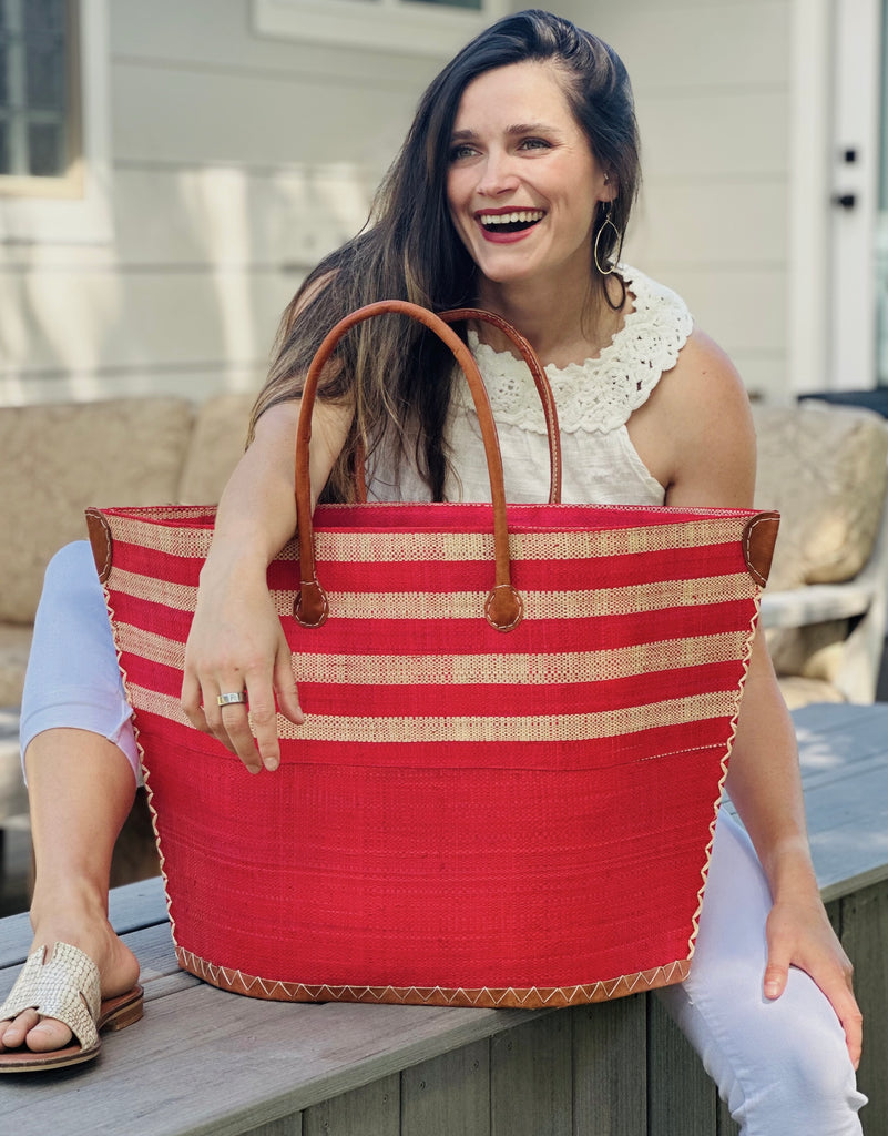 Model wearing Santa Cruz Two Tone Wide Stripes Large Straw Beach Bag Tote Handbag handmade loomed raffia red and natural horizontal stripes on the top half, and solid red on the bottom half with leather handles extra large size - Shebobo