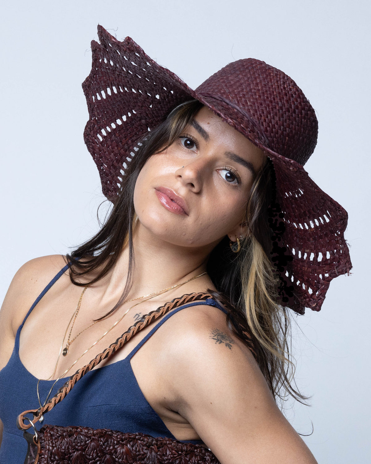 Model wearing Sara 4.5" Brim Woven Straw Sun Hats with Zigzag Edge handmade natural raffia palm fiber in a solid hue of espresso chocolate/dark/brown woven with a subtle crosshatch texture across the crown and spiraling open weave across the brim with matching hat band and zigzag edge - Shebobo