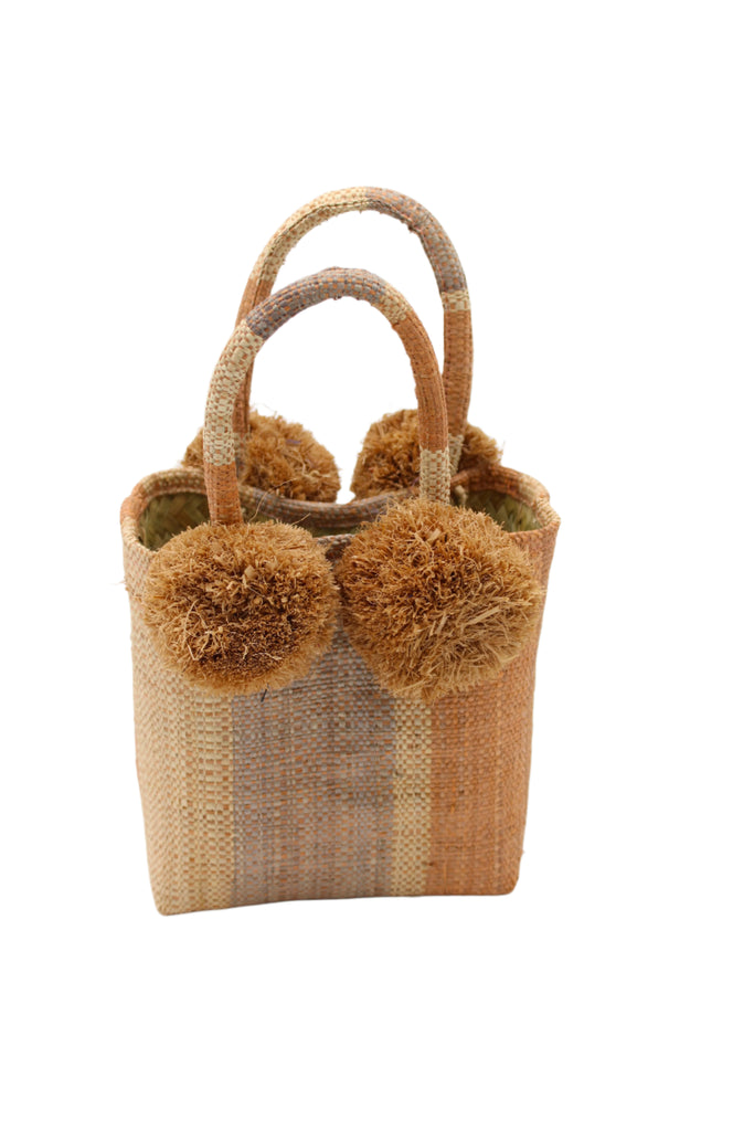 Schooner Blush Swirl Straw Mini Bag with Pompom Accent handmade loomed natural raffia palm fiber in multi width vertical multicolor stripe pattern of blush orange/pink, grey, and natural straw color with four matching raffia pompom embellishments at the base of each handle attachment tiny purse extra small handbag - Shebobo