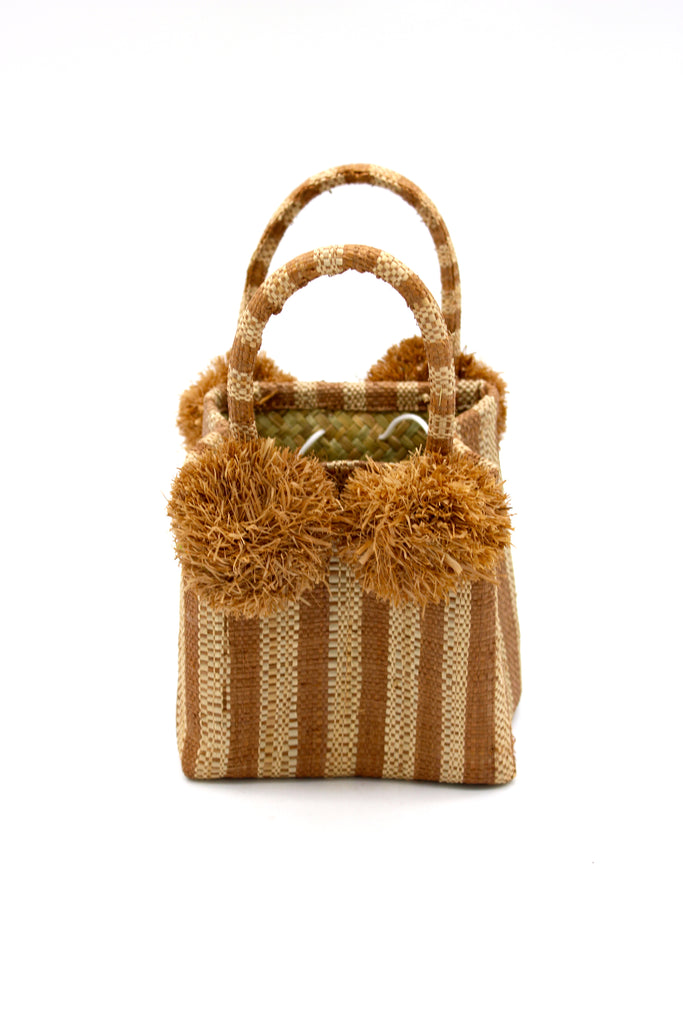 Schooner Cappuccino Stripe Straw Mini Bag with Pompom Accent handmade loomed natural raffia palm fiber in two tones of cappuccino light brown and natural straw color vertical stripe pattern with four matching raffia pompom embellishments at the base of each handle attachment tiny purse extra small handbag - Shebobo