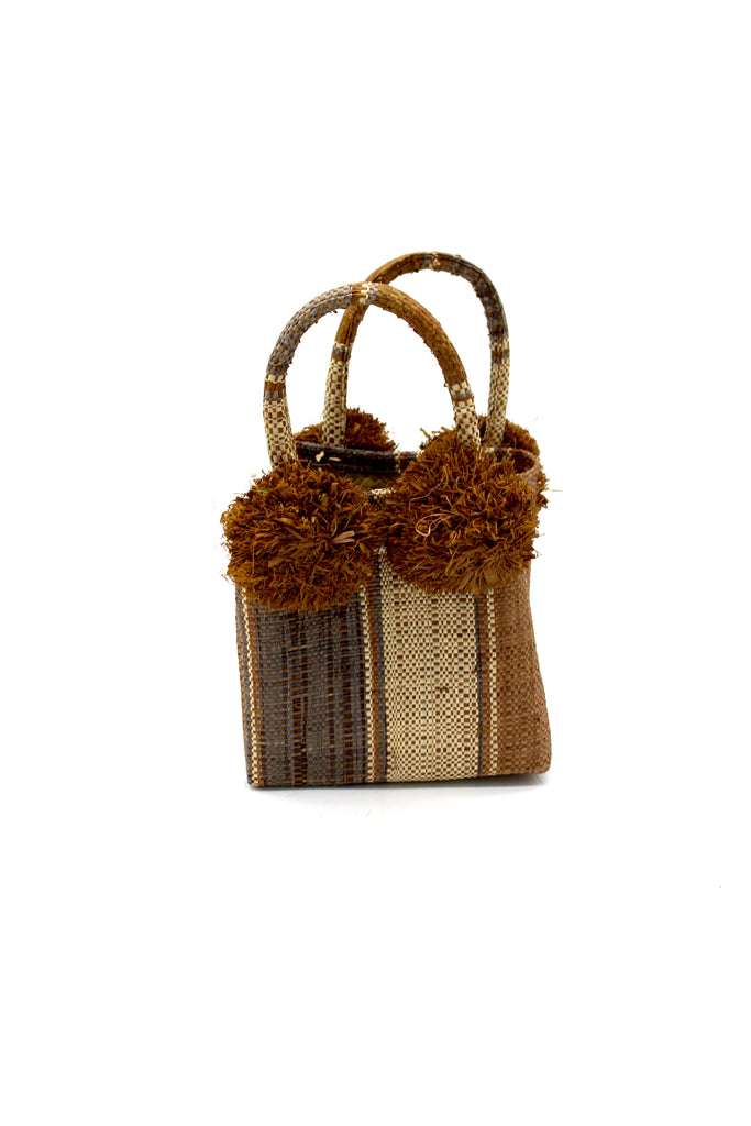 Schooner Cinnamon Swirl Straw Mini Bag with Pompom Accent handmade loomed natural raffia palm fiber in multi width vertical multicolor stripe pattern of cinnamon/tobacco/brown, grey, and natural straw color with four matching raffia pompom embellishments at the base of each handle attachment tiny purse extra small handbag - Shebobo