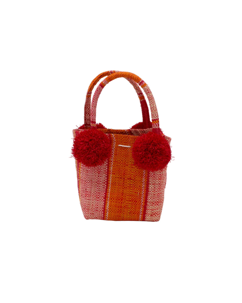 Schooner Red Orange Stripe Straw Mini Bag with Pompom Accent handmade loomed natural raffia palm fiber in multi width vertical multicolor stripe pattern of red, orange, light pink, and natural straw color with four matching raffia pompom embellishments at the base of each handle attachment tiny purse extra small handbag - Shebobo