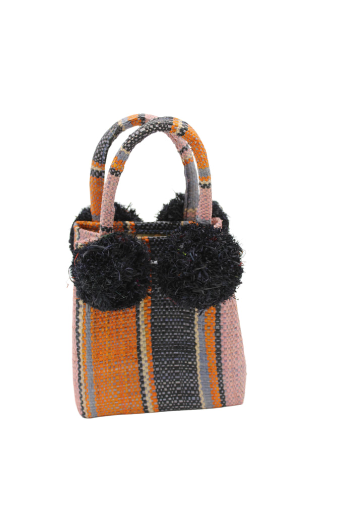 Schooner Retro Swirl Straw Mini Bag with Pompom Accent handmade loomed natural raffia palm fiber in multi width vertical multicolor stripe pattern of denim retro/light/blue, dusk navy/dark/blue, coral orange/red, light pink, black, and natural straw color with four matching raffia pompom embellishments at the base of each handle attachment tiny purse extra small handbag - Shebobo