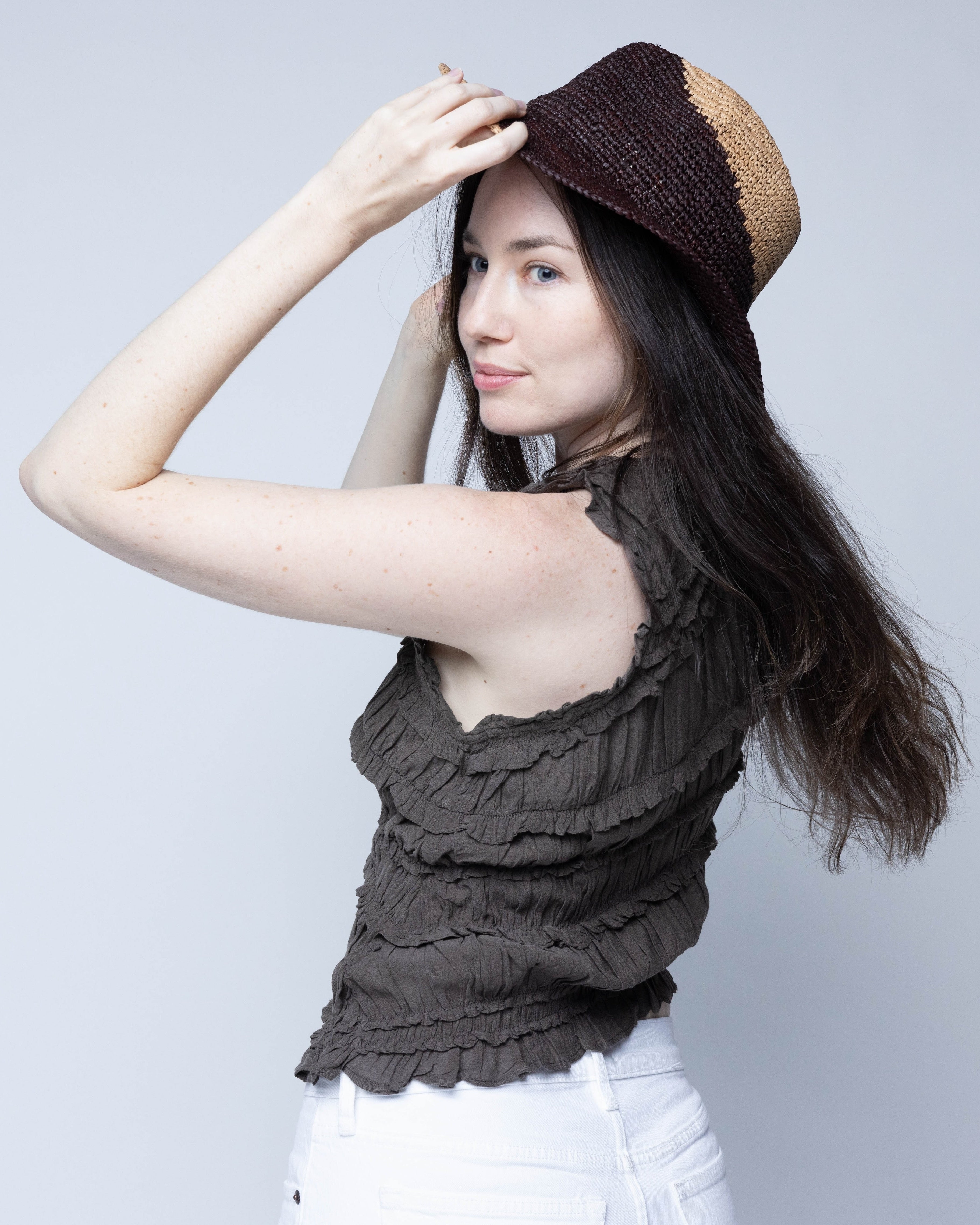 Model wearing Sequoia Cappuccino & Espresso 3" Brim Swirl Crochet Panama Unisex Straw Hats handmade crochet natural raffia palm fiber in a two tone color swirl design of cappuccino tea/light/brown and espresso dark/chocolate/brown spiraling together from wide bands around the brim to a narrow twist at the top of the crown  - Shebobo