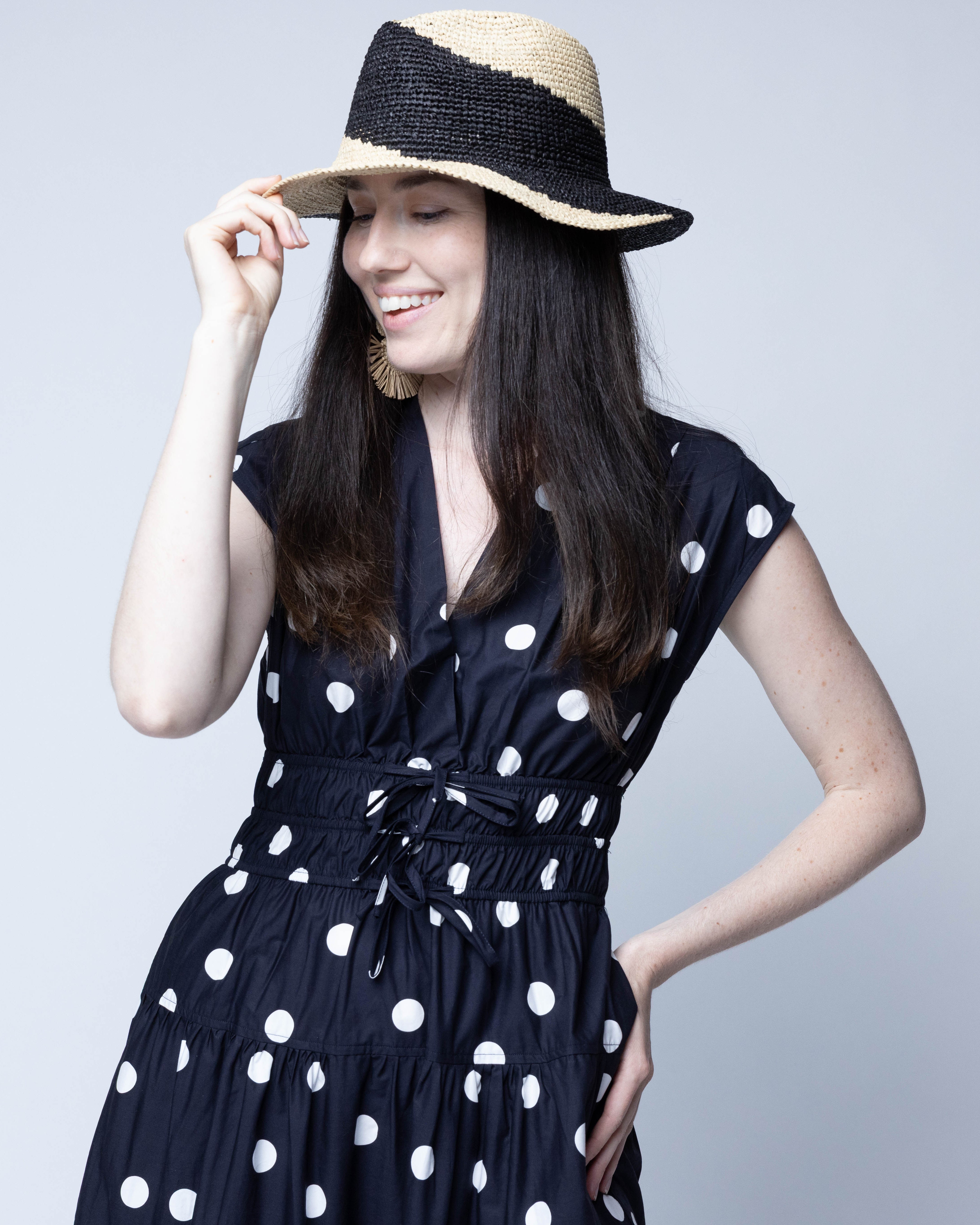 Model wearing Sequoia Black and Natural 3" Brim Swirl Crochet Panama Unisex Straw Hats handmade crochet natural raffia palm fiber in a two tone color swirl design of black and natural straw color spiraling together from wide bands around the brim to a narrow twist at the top of the crown  - Shebobo