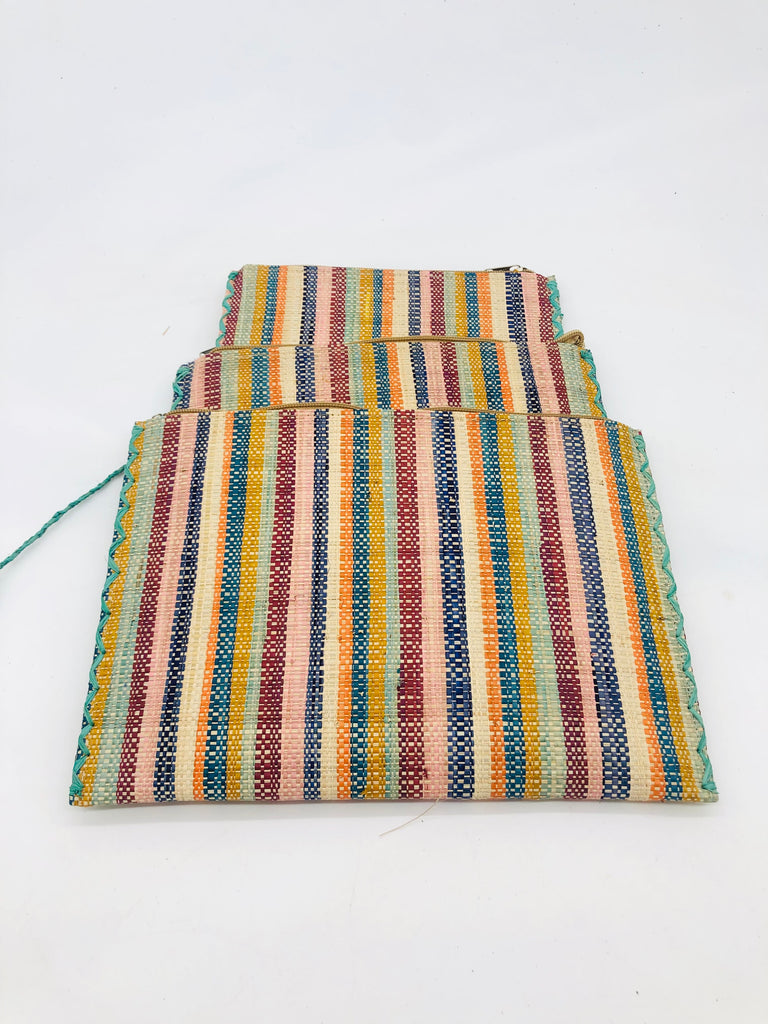 Set of 3 Nesting Zippered Straw Clutches Taffy Multicolor Stripe Pattern handmade loomed raffia in multiple widths of vertical stripes in natural, orange, turquoise, saffron, seafoam, bordeaux, pink with matching zipper and braided zipper pull with cross stitch edging in three sizes of small, medium, and large - Shebobo