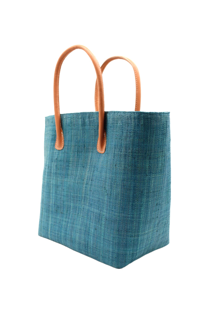 Side view Soubic Straw Basket Bag Turquoise handmade loomed raffia palm fiber in a solid hue of turquoise blue large tote bag with leather handles handbag top handle beach bag - Shebobo