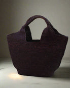 Lifestyle view St. Tropez Heart Shaped Crochet Straw Basket Handbag handmade crochet natural raffia palm fiber in a solid hue of Mocha chocolate/dark/brown with a subtle link texture beach bag shoulder bag - Shebobo