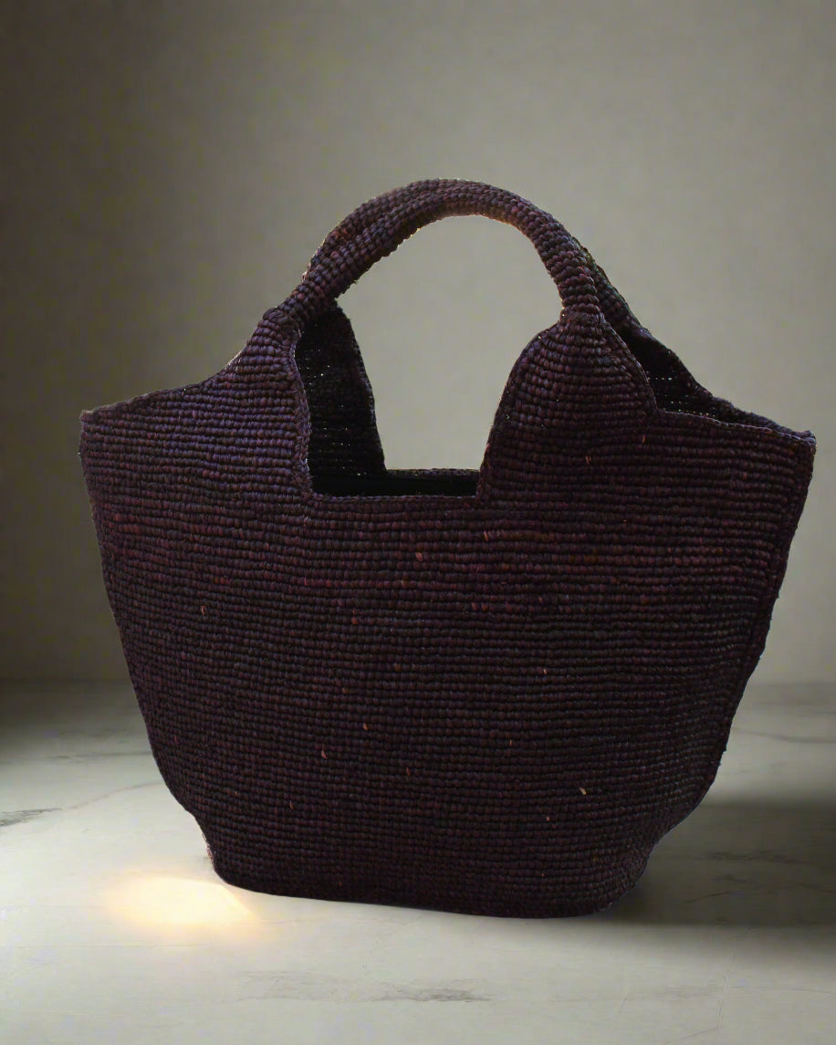 Lifestyle view St. Tropez Heart Shaped Crochet Straw Basket Handbag handmade crochet natural raffia palm fiber in a solid hue of Mocha chocolate/dark/brown with a subtle link texture beach bag shoulder bag - Shebobo