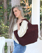 Model wearing St. Tropez Heart Shaped Crochet Straw Basket Handbag handmade crochet natural raffia palm fiber in a solid hue of Mocha chocolate/dark/brown with a subtle link texture beach bag shoulder bag - Shebobo