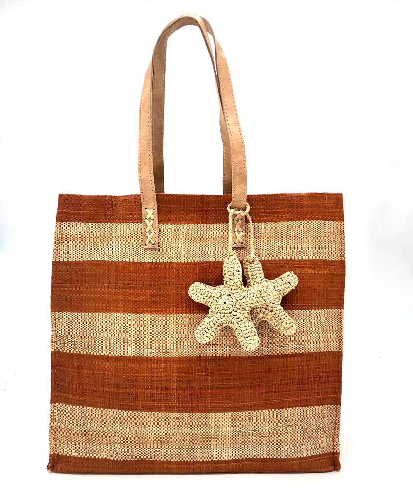 Starfish Caramel Straw Bag with Crochet Starfish Charm Embellishment handmade loomed raffia shopping tote in caramel red/brown and natural straw color horizontal wide stripe pattern handbag with leather handles - Shebobo