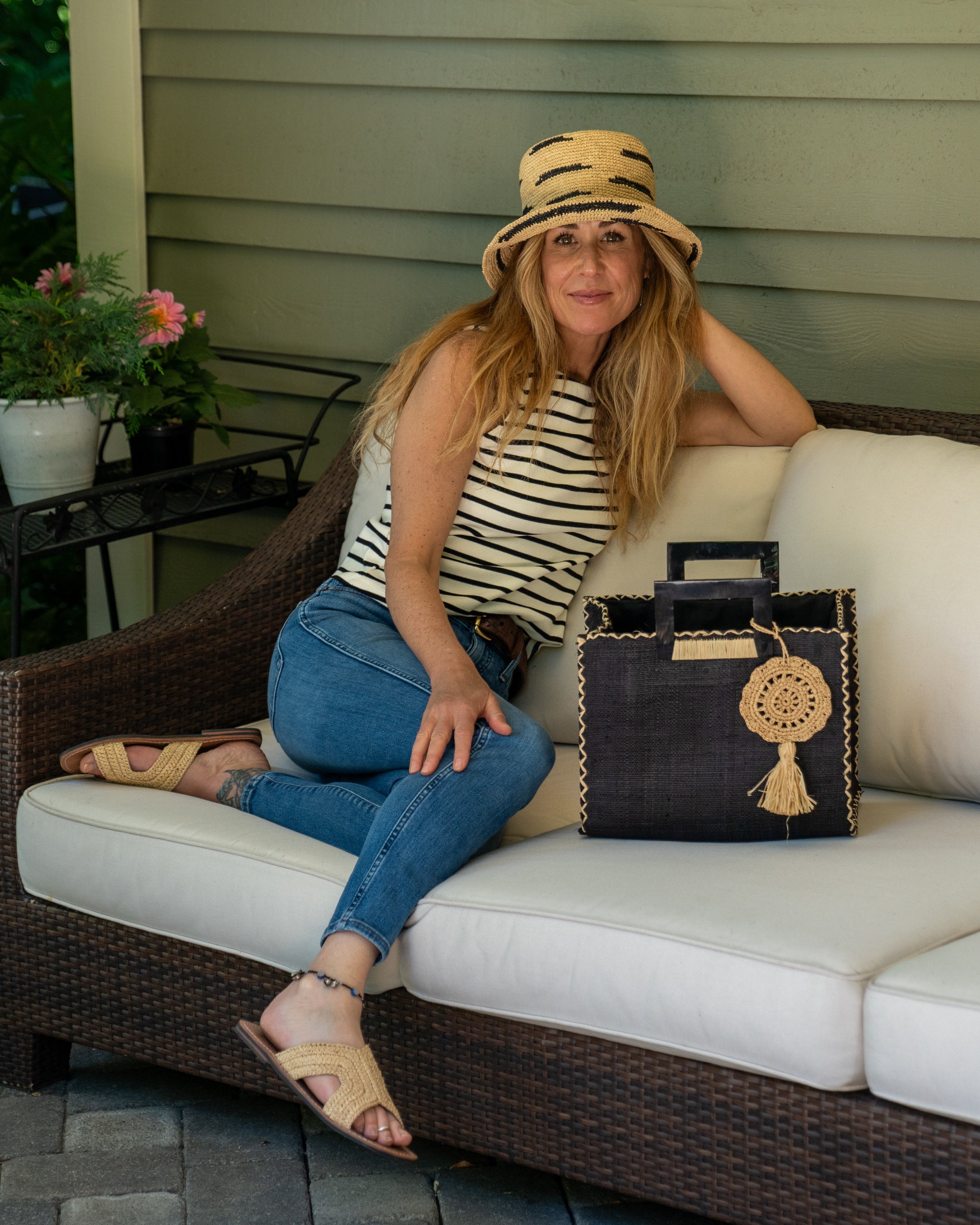 Model wearing Stevie Square Black Multicolor Straw Handbag with Horn Handles handmade loomed raffia in black purse with matching liner, contrasting natural cross stitch edging, handle attachment, and crochet doily tassel charm embellishment - Shebobo