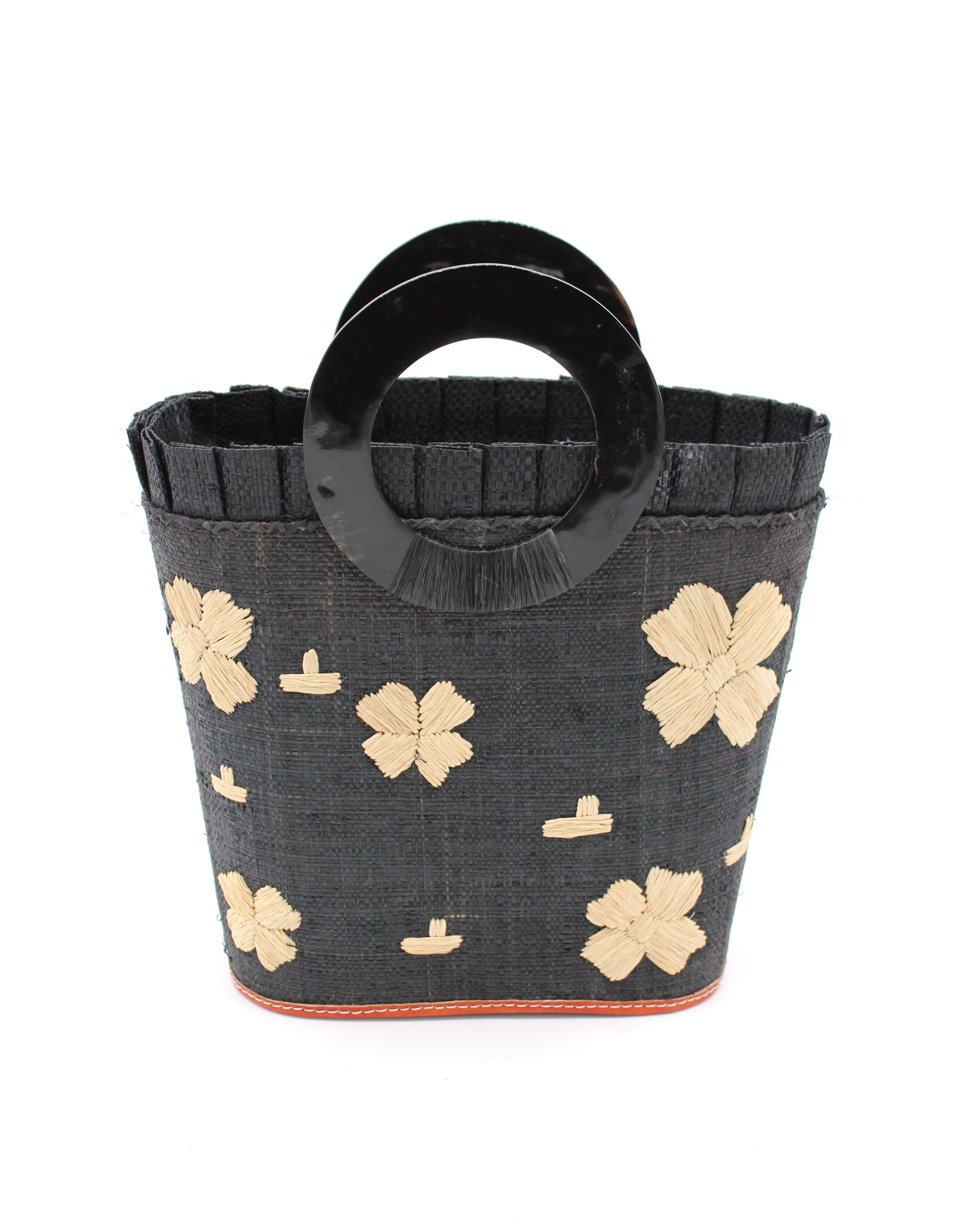 Tulum Straw Bucket Bag with Flower Embroidery and Horn Handle Black Purse with Ruffle Edge handmade loomed raffia palm fiber in a solid hue of black with natural straw color hand embroidered floral pattern with multiple sized flowers and raffia ruffle on the opening  handbag - Shebobo