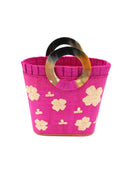 Tulum Straw Bucket Bag with Flower Embroidery and Horn Handle Fuchsia Purse with Ruffle Edge handmade loomed raffia palm fiber in a solid hue of fuchsia hot/bright/barbie/pink with natural straw color hand embroidered floral pattern with multiple sized flowers and raffia ruffle on the opening  handbag - Shebobo