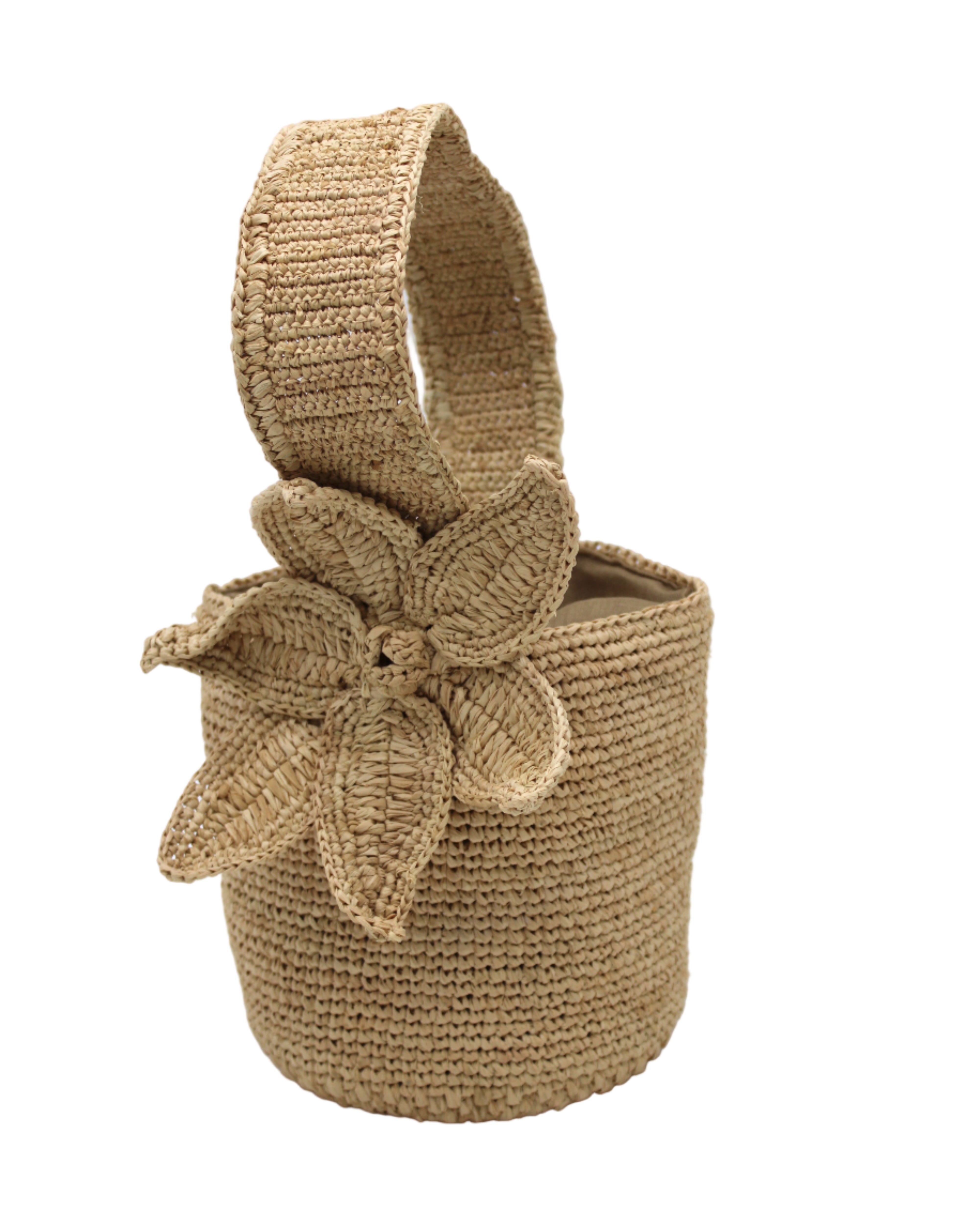 Side view Valencia Mini Crochet Petit Straw Basket Handbag with Flower Embellishment handmade natural raffia palm fiber in a solid hue of Natural straw color crochet in bands of horizontal link pattern texture with integrated strap handle and large flower embellishment - Shebobo