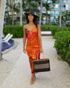 Model wearing Wynwood Black Straw Basket Bag Handbag with Metallic Detailing handmade loomed raffia in black and silver metallic vegan leather in three evenly sized horizontal bands of color with the metallic weave centered on the purse with leather binding and handles - Shebobo (with Panama Black Unisex Straw Hat)