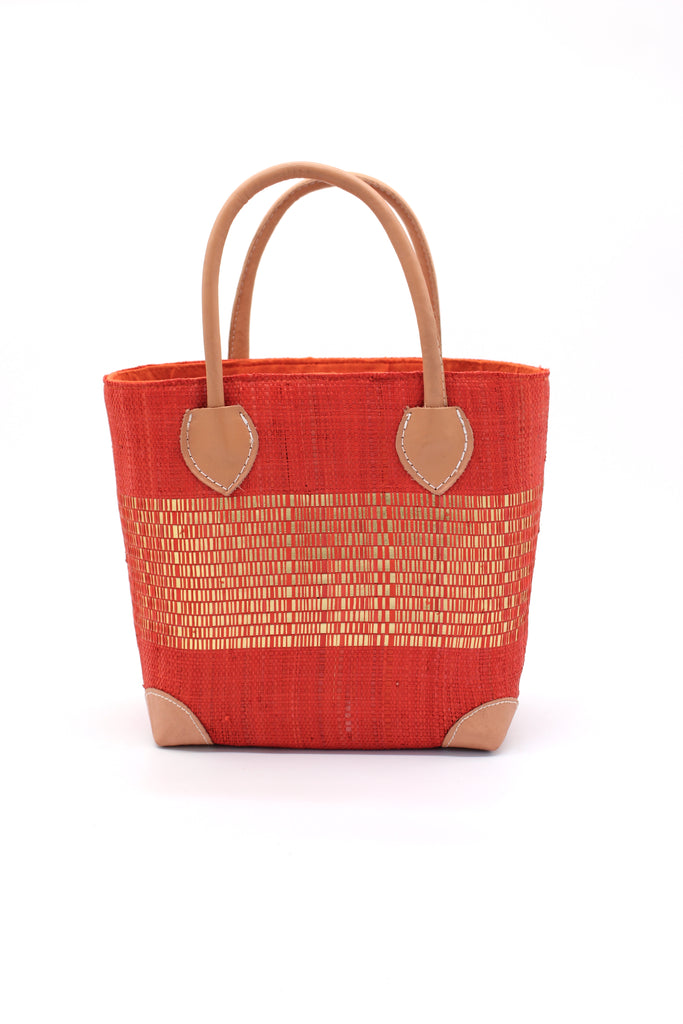 Wynwood Coral Straw Basket Bag with Metallic Detailing Handmade loomed raffia palm fiber in a solid hue of coral orange/red with a wide horizontal band of metallic strands woven in seamlessly handbag purse with leather handles - Shebobo