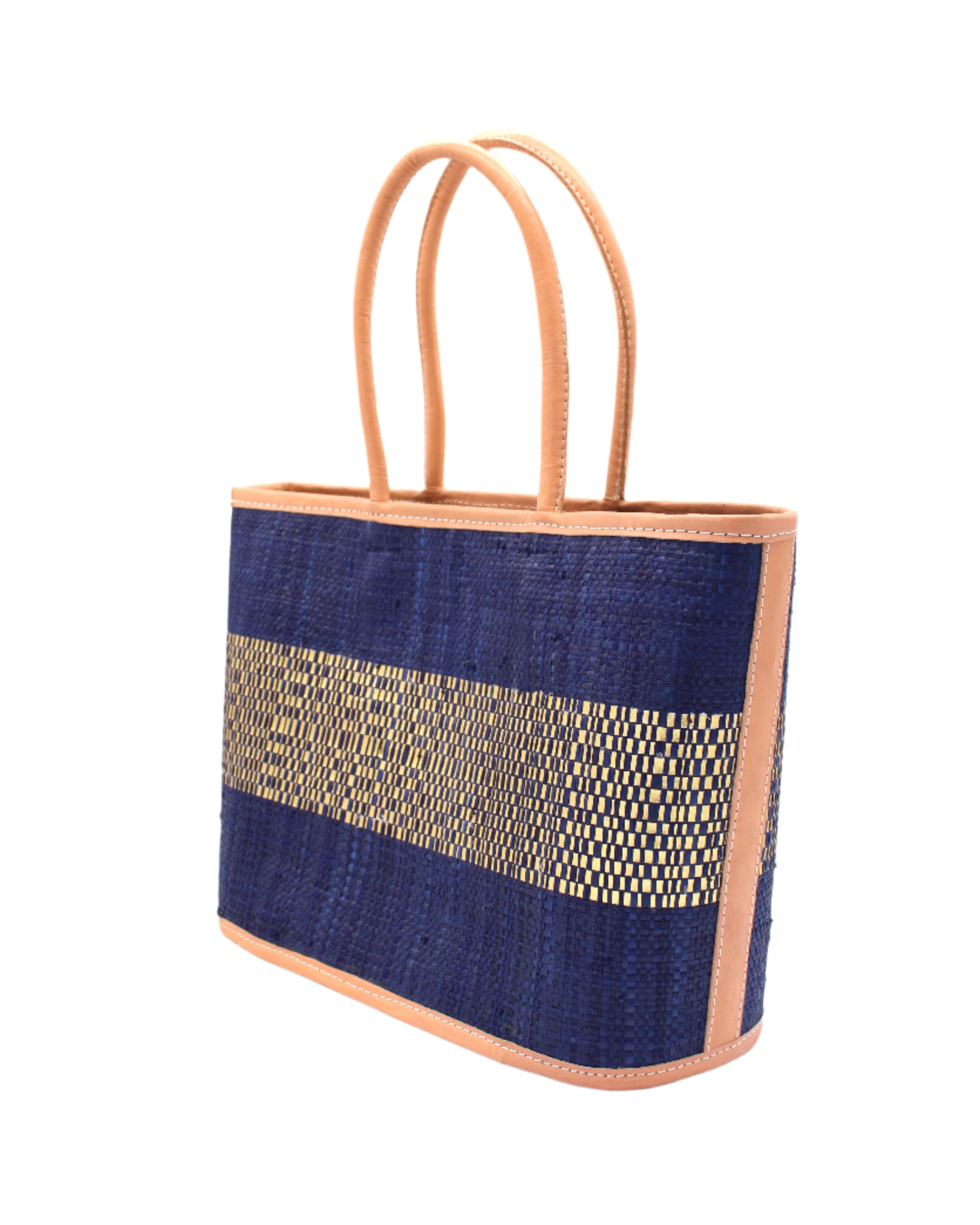 Side View Wynwood Blue Straw Basket Bag Handbag with Metallic Detailing handmade loomed raffia in blue and silver metallic vegan leather in three evenly sized horizontal bands of color with the metallic weave centered on the purse with leather binding and handles - Shebobo