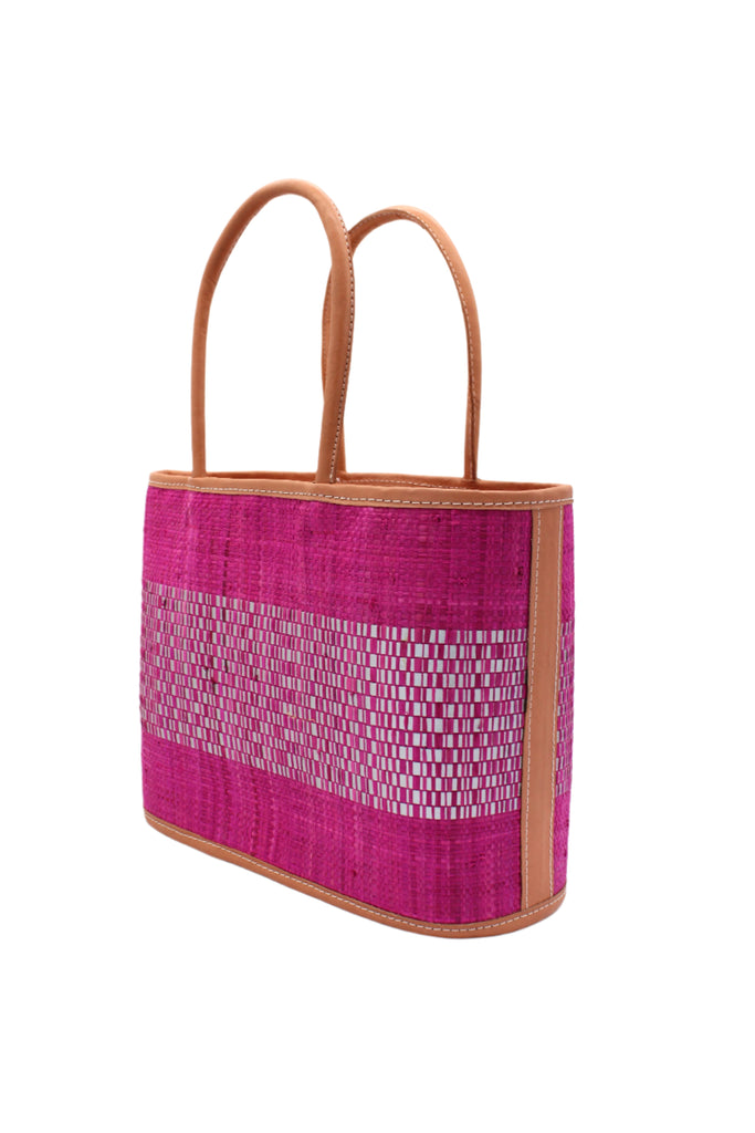 Side View Wynwood Fuchsia Straw Basket Bag Handbag with Metallic Detailing handmade loomed raffia in fuchsia pink and silver metallic vegan leather in three evenly sized horizontal bands of color with the metallic weave centered on the purse with leather binding and handles - Shebobo