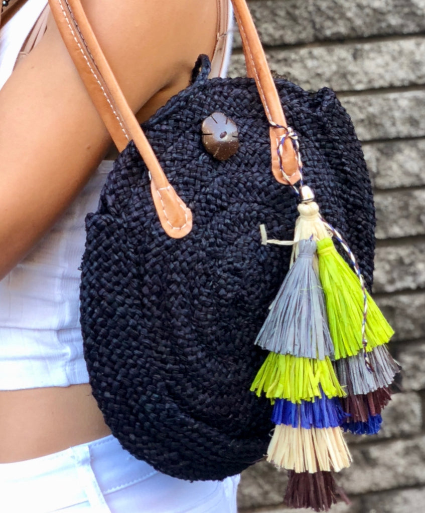 Model wearing Tassels Layered Raffia Tufts Charm Embellishment Yerba Multicolor handmade knotted and brushed natural raffia palm fiber in a multicolor layered tuft tassel of natural straw color, lime green, grey, chocolate dark/brown, and dusk navy/dark/blue beach bag handbag charm embellishment or party decor - Shebobo