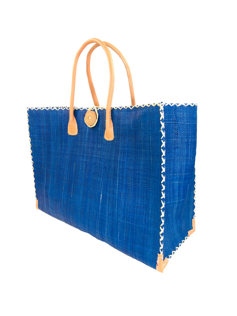 Zafran Large Straw Beach Bag with Plastic Liner handmade loomed raffia in Navy deep blue with contrasting cross stitch edge binding, wood button closure, and leather handles & feet plus assorted print plastic lining - Shebobo