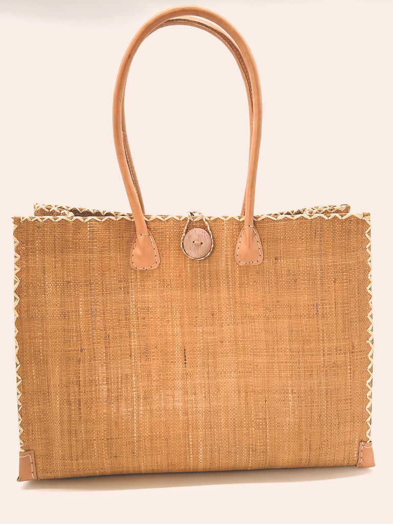 Zafran Large Straw Beach Bag with Plastic Liner handmade loomed raffia in Blush pink/orange with contrasting cross stitch edge binding, wood button closure, and leather handles & feet plus assorted print plastic lining - Shebobo