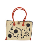 Zafran Natural & Black Embroidered Straw Beach Bag with Floral Pattern handmade natural raffia palm fiber in a solid hue of natural straw color with asymmetrical floral leaf, vine, and flower pattern in black with matching cross-stitch edging, leather handles, and wooden button closure shoulder bag handbag tote - Shebobo