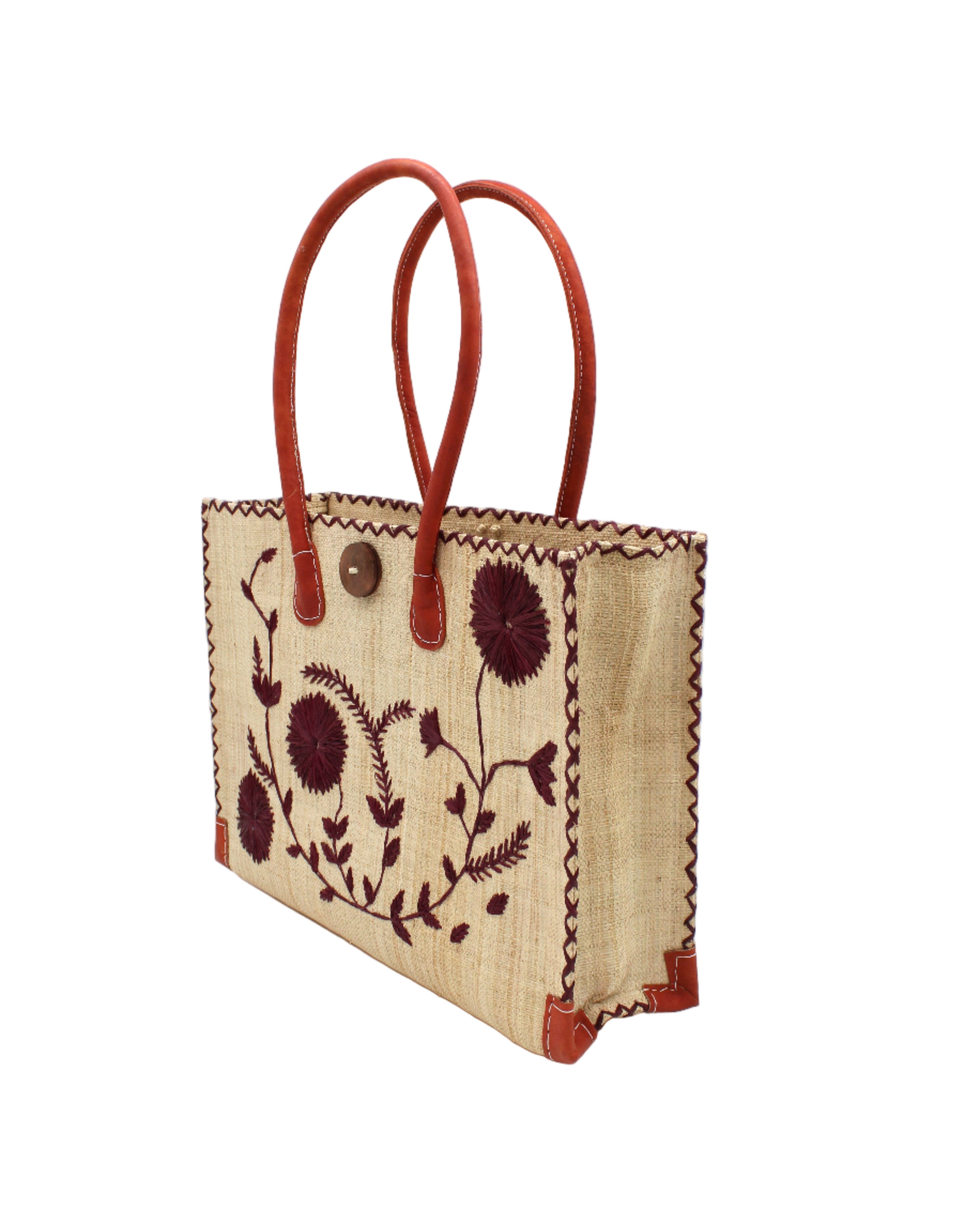 Side view Zafran Natural & Black Embroidered Straw Beach Bag with Floral Pattern handmade natural raffia palm fiber in a solid hue of natural straw color with asymmetrical floral leaf, vine, and flower pattern in umberwine burgundy/bordeaux/claret/dark/red/purple with matching cross-stitch edging, leather handles, and wooden button closure shoulder bag handbag tote - Shebobo 