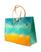 Side view Holden Turquoise Ombre Zafran Straw Beach Bags handmade dip dyed raffia woven into a three part horizontal ombre pattern of turquoise blue on the top, seafoam blue/green in the middle and both sides, and saffron yellow on the bottom with cross stitch edging, wooden button, and leather handles - Shebobo