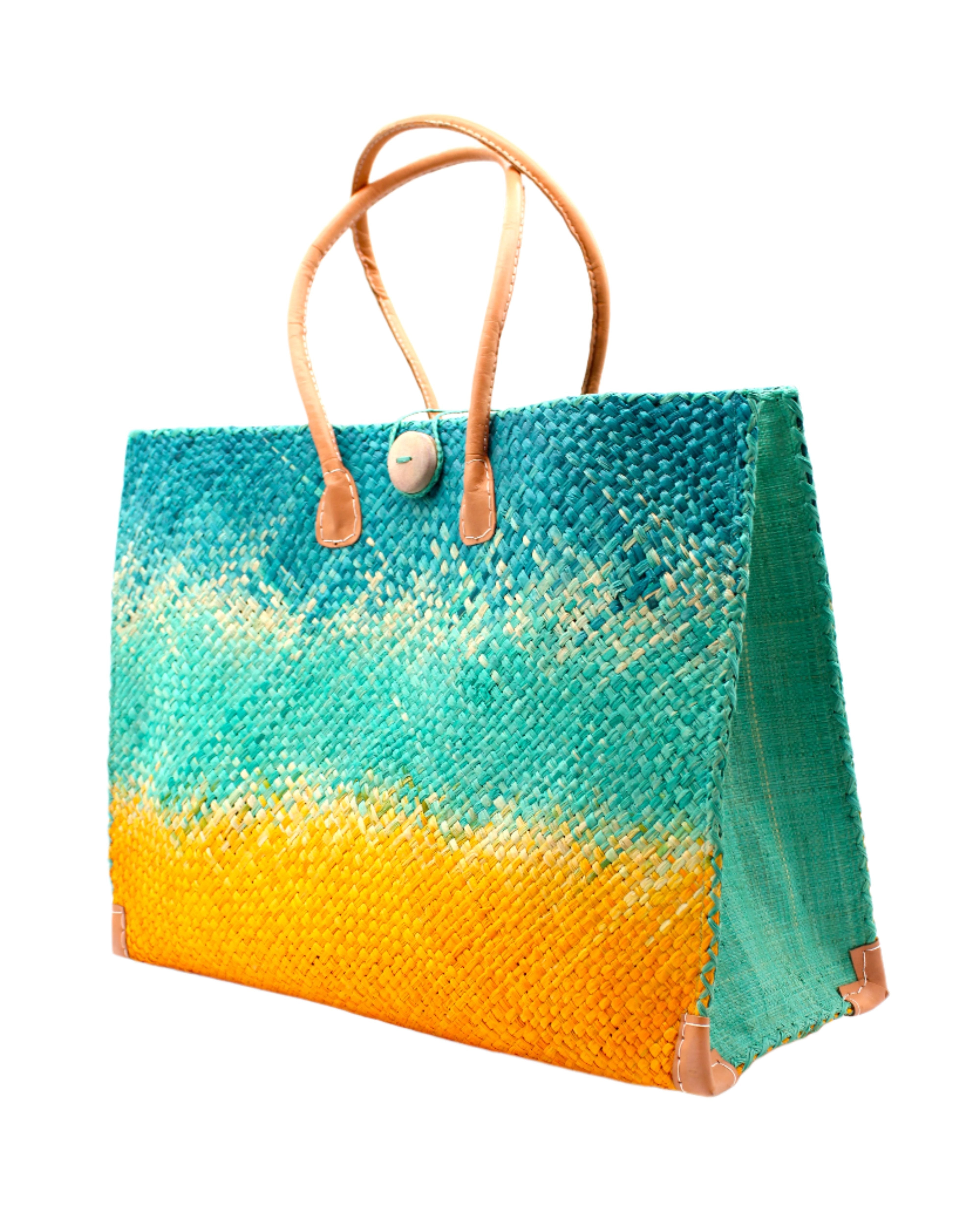 Side view Holden Turquoise Ombre Zafran Straw Beach Bags handmade dip dyed raffia woven into a three part horizontal ombre pattern of turquoise blue on the top, seafoam blue/green in the middle and both sides, and saffron yellow on the bottom with cross stitch edging, wooden button, and leather handles - Shebobo