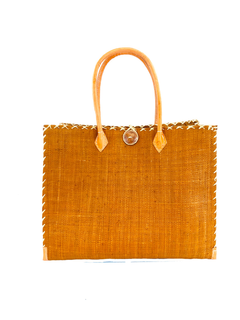 Zafran Large Straw Beach Bag with Plastic Liner handmade loomed raffia in cinnamon/tobacco/brown with contrasting cross stitch edge binding, wood button closure, and leather handles & feet plus assorted print plastic lining - Shebobo