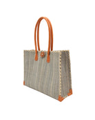 Side view Zafran Grey Pinstripes Large Straw Beach Bag with Plastic Liner handmade loomed raffia tote in wide bands of gray with narrow bands of natural straw color that make a vertical pinstripe pattern with assorted print plastic lining and leather handles xl bag - Shebobo