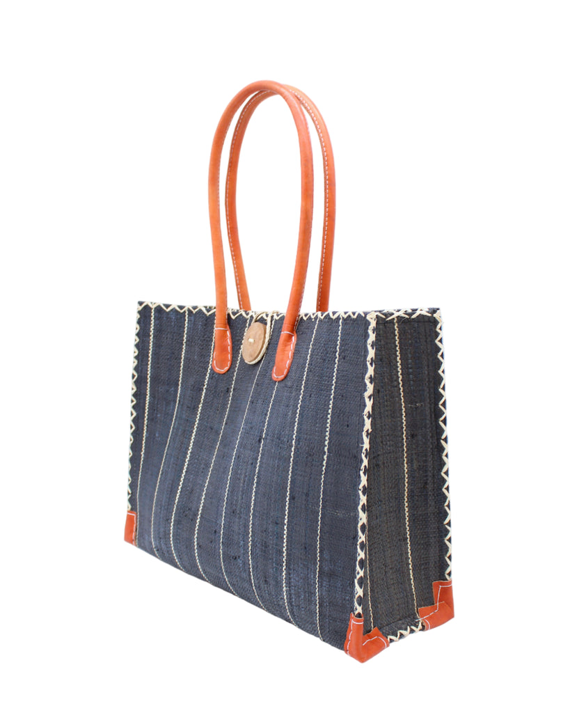 Side view Zafran Black Pinstripes Large Straw Beach Bag with Plastic Liner handmade loomed raffia tote in wide bands of black with narrow bands of natural straw color that make a vertical pinstripe pattern with assorted print plastic lining and leather handles xl bag - Shebobo