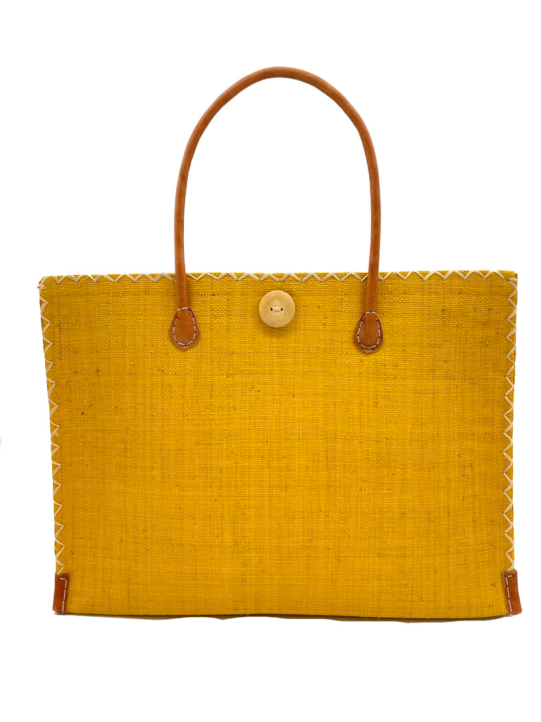 Zafran Large Straw Beach Bag with Plastic Liner handmade loomed raffia in Saffron yelow with contrasting cross stitch edge binding, wood button closure, and leather handles & feet plus assorted print plastic lining - Shebobo