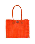 Zafran Straw Beach Bag with Plastic Liner handmade loomed raffia in a solid hue of Coral orange/red with contrasting natural straw color cross stitch edge binding, wood button closure, and leather handles & feet plus assorted print plastic lining - Shebobo