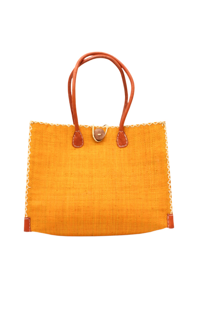 Zafran Straw Beach Bag with Plastic Liner handmade loomed raffia in a solid hue of saffron yellow/orange with contrasting natural straw color cross stitch edge binding, wood button closure, and leather handles & feet plus assorted print plastic lining - Shebobo