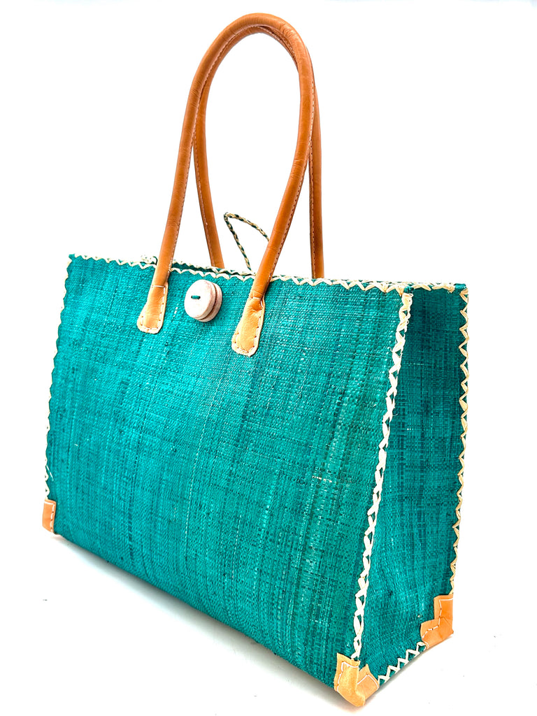 Zafran Large Straw Beach Bag with Plastic Liner handmade loomed raffia in Teal blue/green with contrasting cross stitch edge binding, wood button closure, and leather handles & feet plus assorted print plastic lining - Shebobo