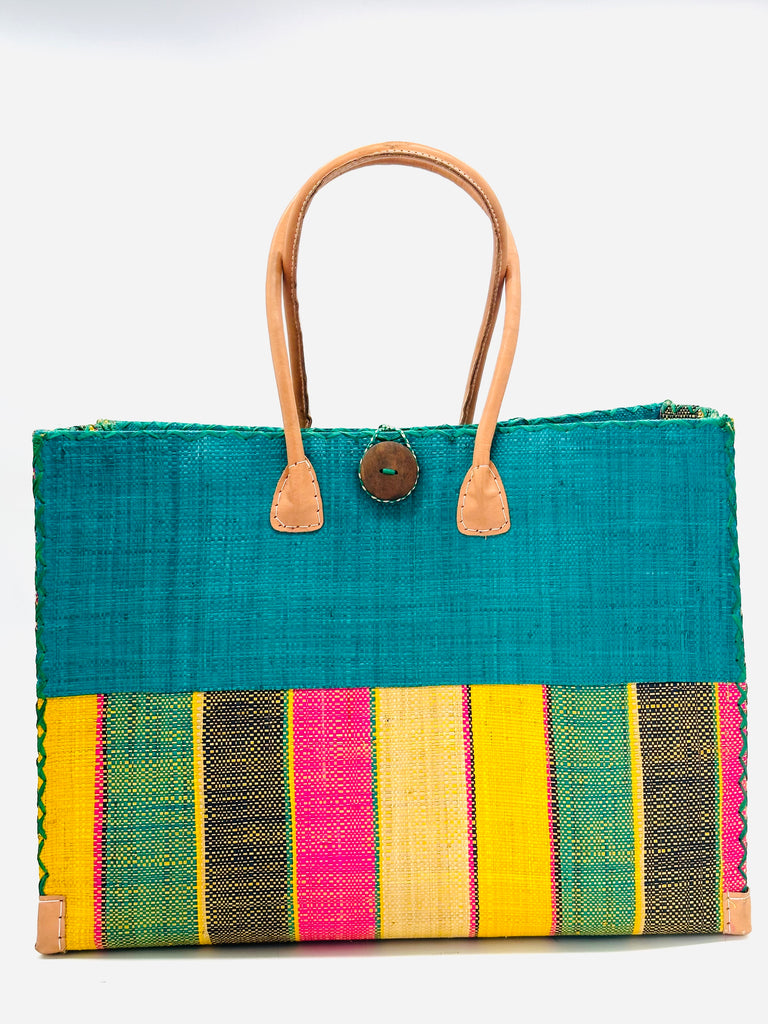 Zafran Two Tone Carmalita Multicolor Stripes Beach Straw Bag with Plastic Liner handmade loomed raffia color block with the top half solid turquoise blue and the bottom half multi width vertical stripes of Black, Turquoise, Fuchsia Pink, and Saffron Yellow - sides of bag are same stripe pattern - with wood button and leather handles & accents - Shebobo