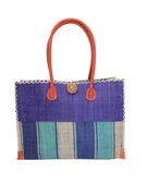 Zafran Two Tone Wide Stripe Blue Swirl Straw Beach Bag handmade loomed raffia palm fiber in a solid hue of dusk/navy/dark blue on the top half of the bag and a multicolor multi-width vertical stripe pattern of blue, turquoise, and natural straw color on the bottom half of the bag with leather handles and feet and matching crosshatch stitch edging shoulder bag - Shebobo